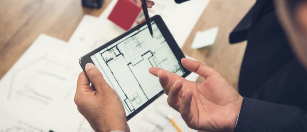 Go Doors Select Automated Door Service Agreements Professional reviewing automatic door plans on a tablet, discussing service agreements and maintenance schedules.