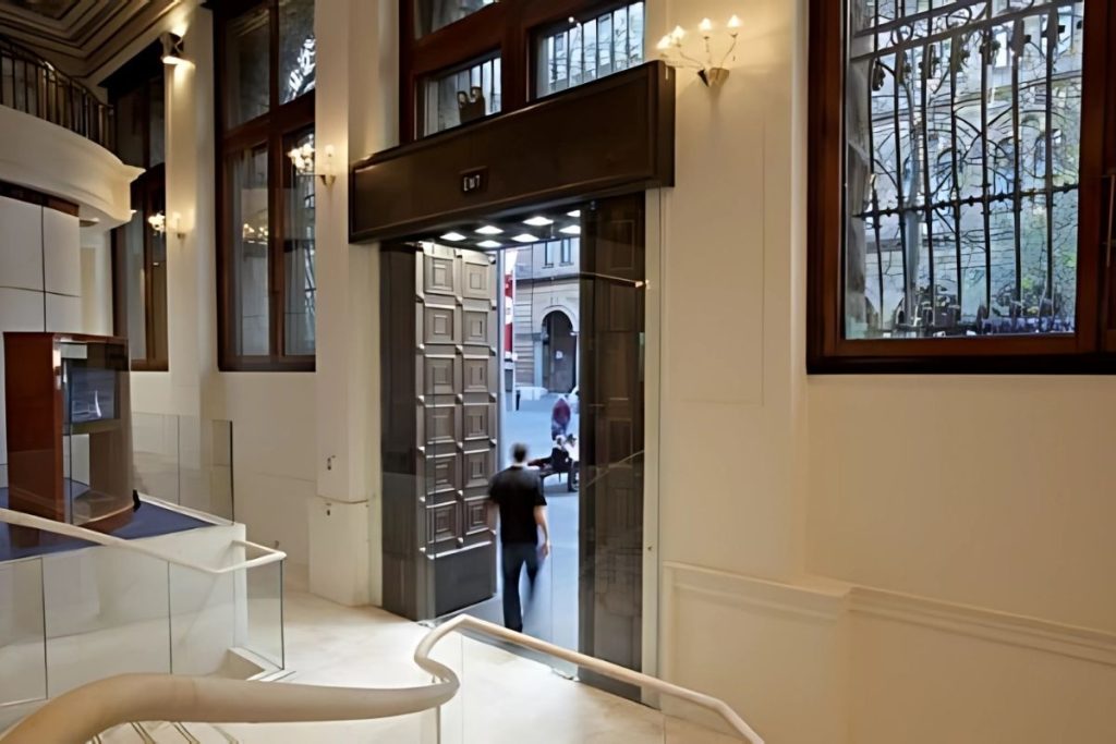 Automatic sliding glass doors integrated behind decorative heritage-style main entrance.