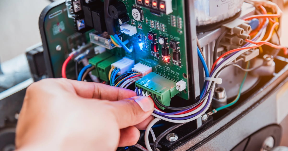 Technician conducting automatic gate repairs on a motor.