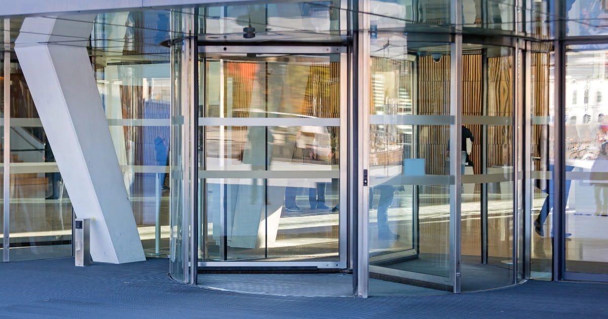 Glass revolving door system providing automated access to a contemporary office building.