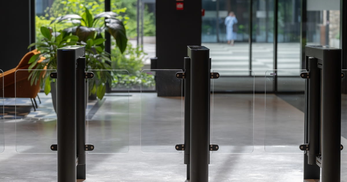 Electronic access control gates at the entrance to a contemporary office building.